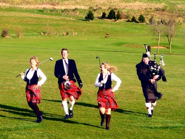 Club Captain, Andrew Macgregor-Boyle being escorted to the tee by his wife Sue and niece Sam and accompanied by a lone piper�