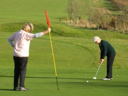 The new Ladies' Captain, Josie Knight, holds the flag whilst the retiring captain, Shirley Blount, drives out
