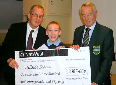 Outgoing Club Captain Dennis Baker presents a cheque to Bob Wall, Headmaster of the Hillside School in Portslade, assisted by Michael, one of the pupils