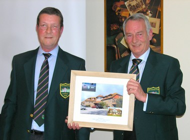 New Club Captain Andrew Macgregor-Boyle presents a framed picture of the clubhouse to the outgoing Club Captain Dennis Baker